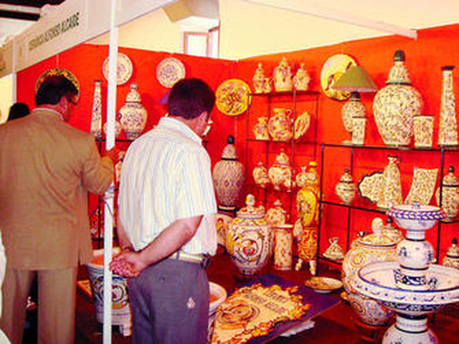 Visitantes de la exposición contemplan un stand.