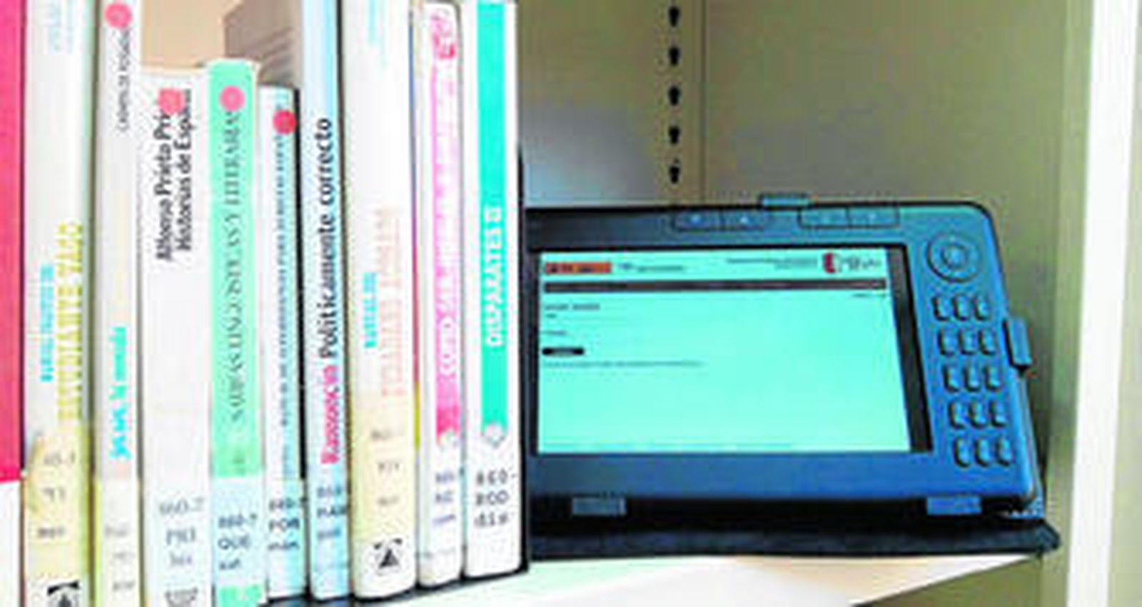 Algunos de los títulos que se pueden encontrar en la Poeta Rafael Esteban Poullet, junto a un lector electrónico para libros digitales.