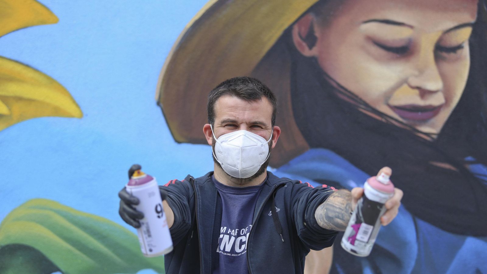 El artista Lalone con su herramienta, dos botes de spray.