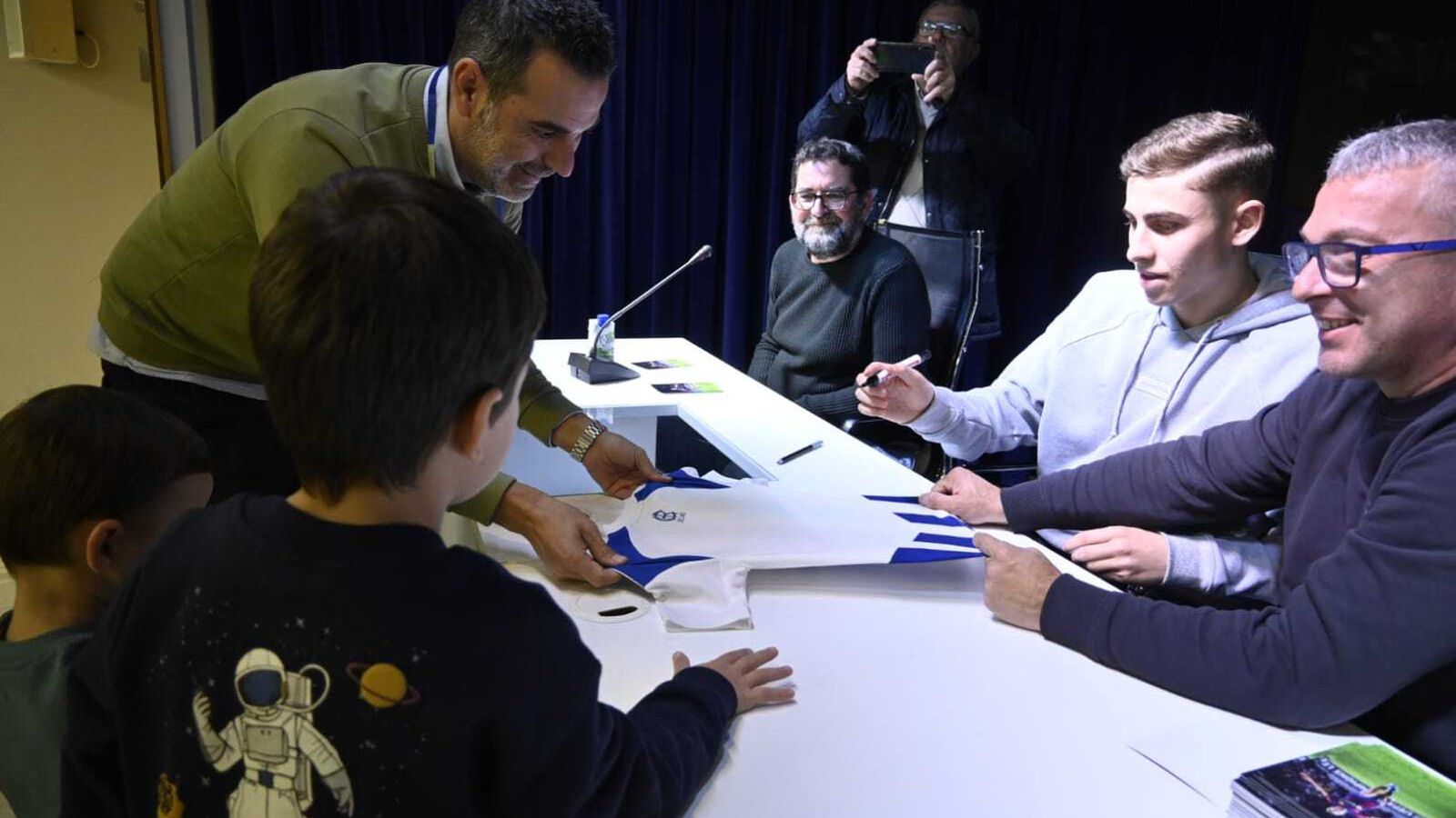 Fermín López firma una camiseta del Recreativo de Huelva.
