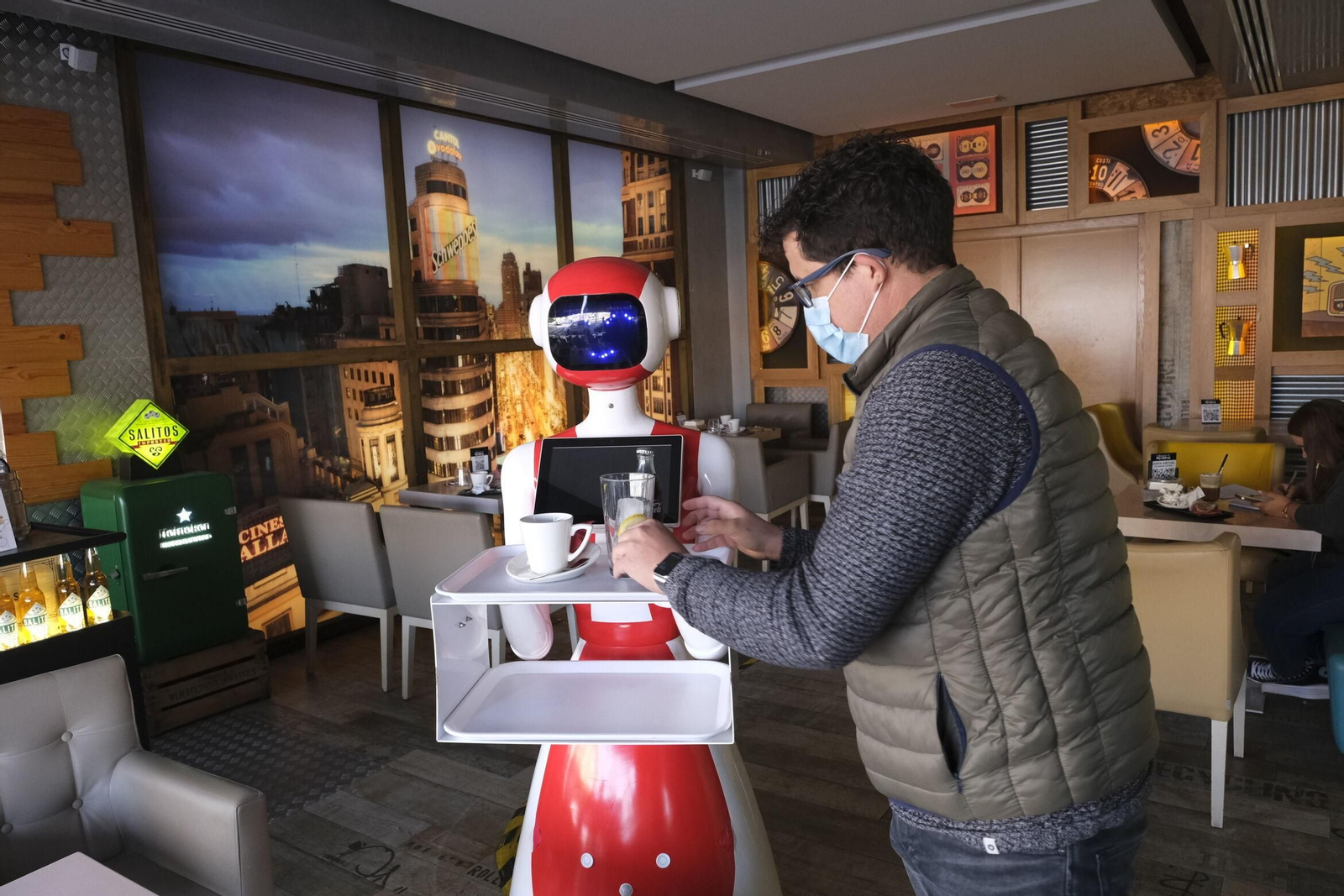 En sus dos bandejas porta las consumiciones para los clientes