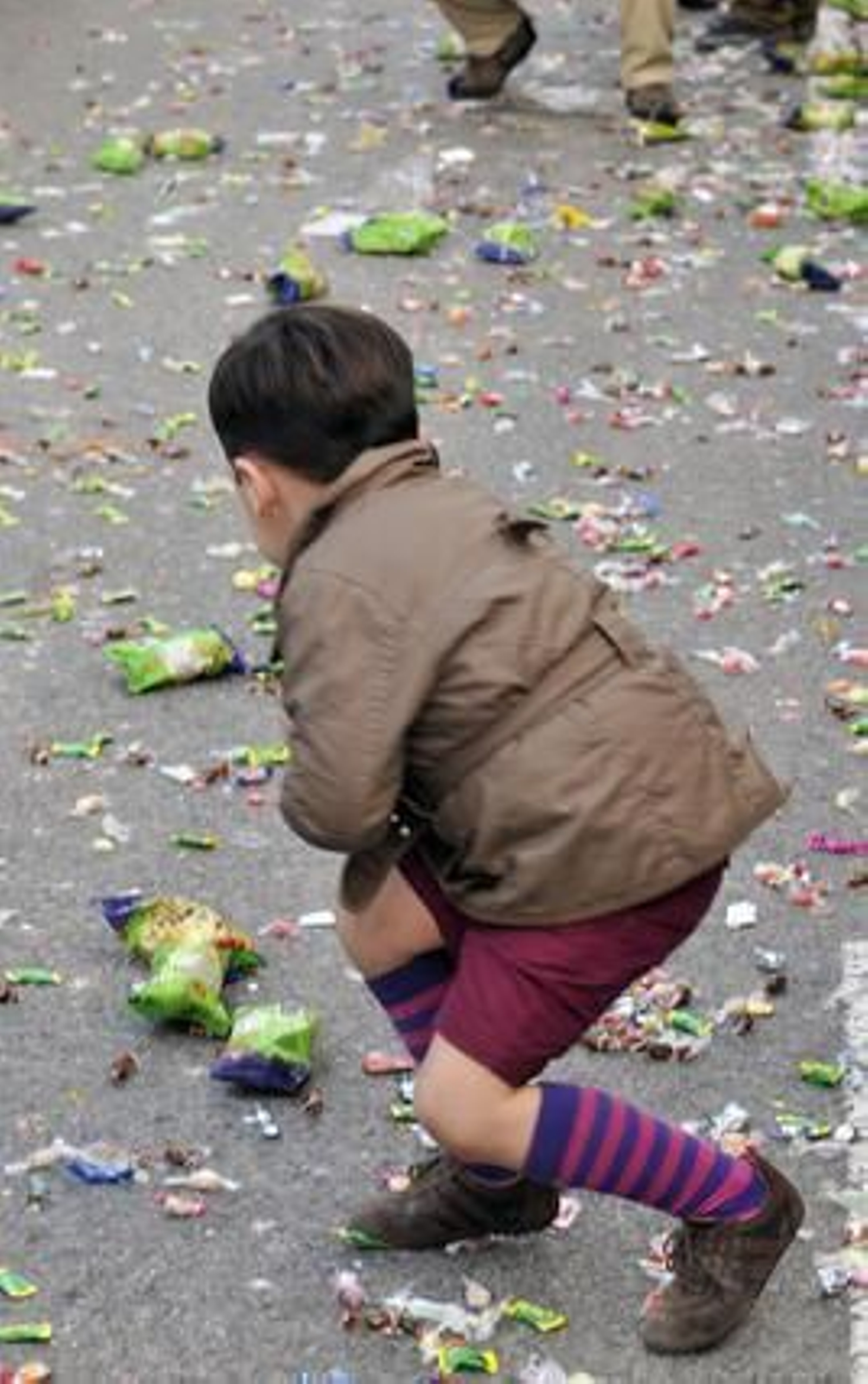 Un niño recoje los caramelos que las carrozas han dejado a su paso.

Foto: Juan Carlos Vázquez