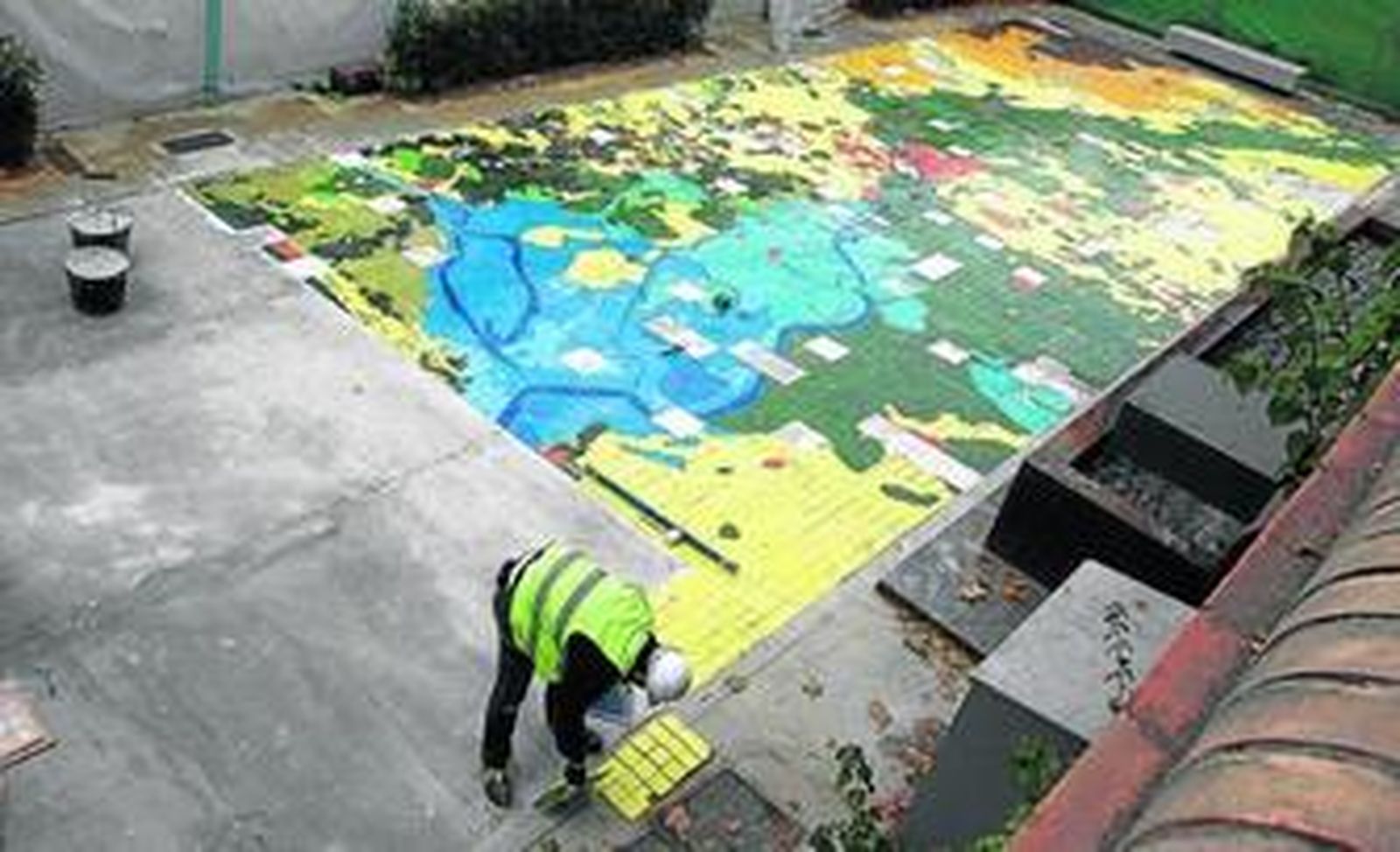Los operarios rematan en estos días el gran mosaico sobre el río Guadalquivir.