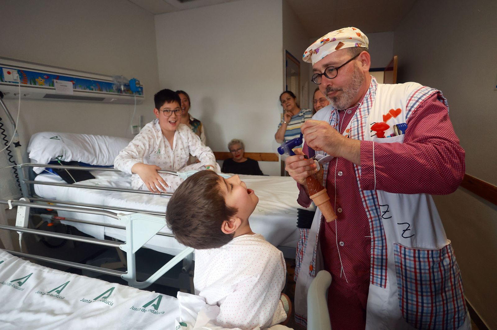 Los menores de Pediatría del Hospital Juan Ramón Jiménez reciben a los Doctores Sonrisa de la Fundación nacional Theodora, en imágenes