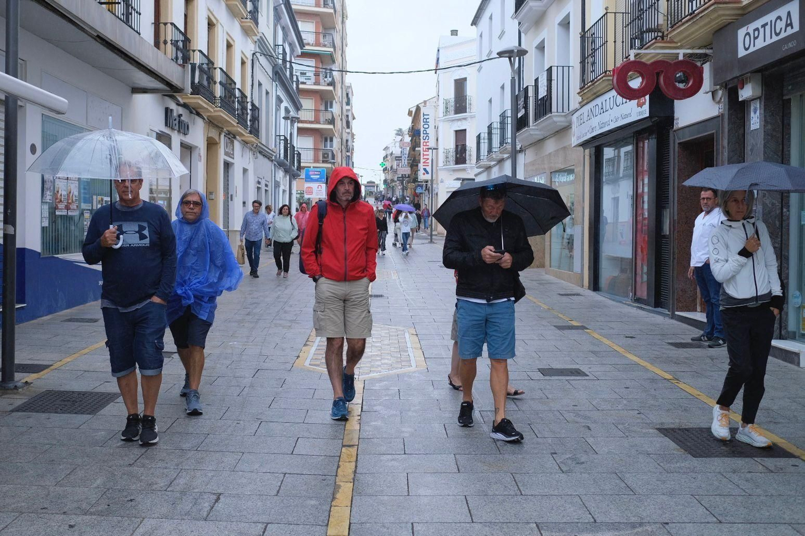 Varios turistas caminando bajo la lluvia en Ronda