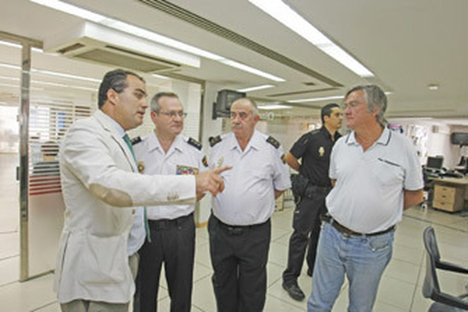 El director de Diario de Jerez, David Fernández, muestra la redacción al comisario Garrido y al segundo jefe, Francisco Álvarez, junto al redactor M. Moure. /Pascual