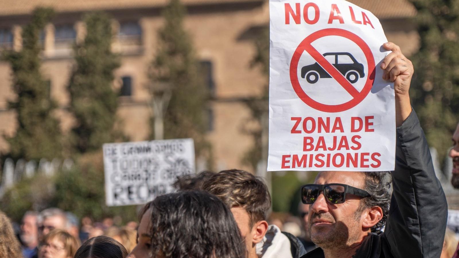 Un participante muestra una pancarta en contra de la ZBE