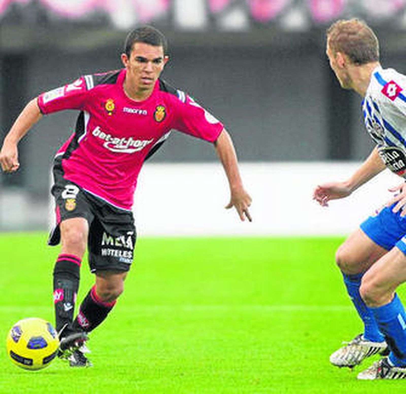 El mallorquinista Ratinho conduce el balón en presencia de Seoane.