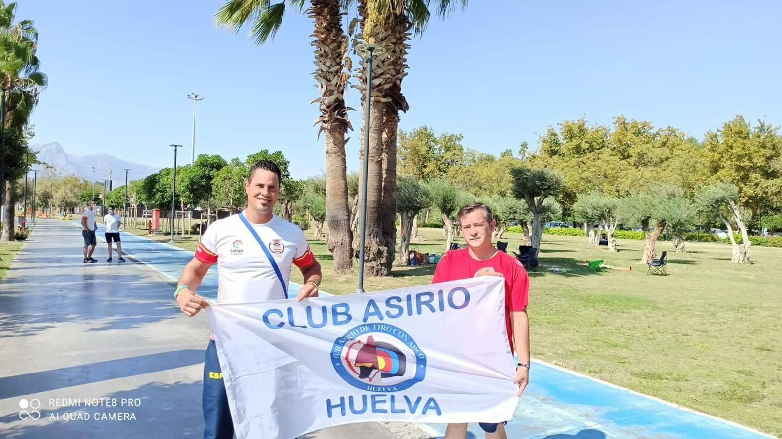 Miguel Ángel Medina y Agustín Rodríguez posan con la bandera del Club Asirio.