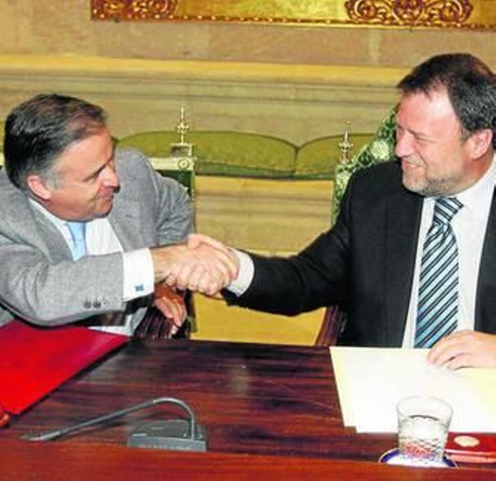 El notario Antonio Ojeda estrecha la mano de Monteseirín.