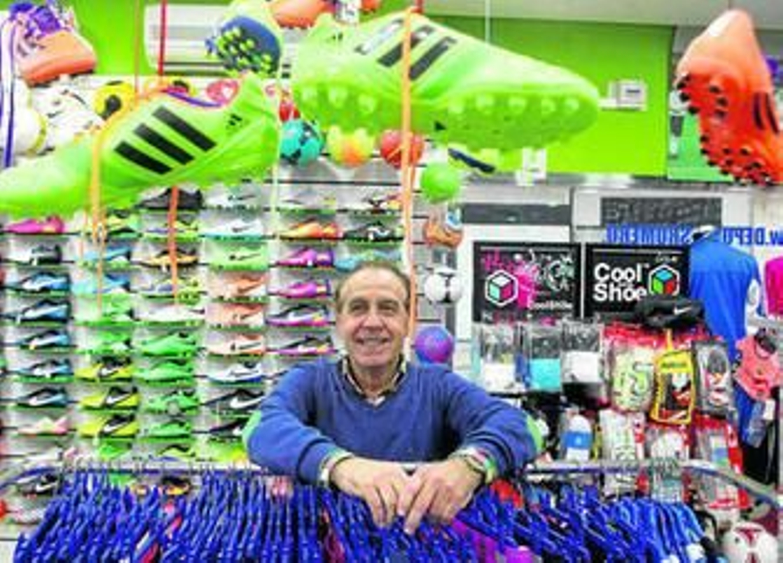 Paco Romero se apoya en un expositor de su tienda de deportes mientras posa para 'Diario de Cádiz'.