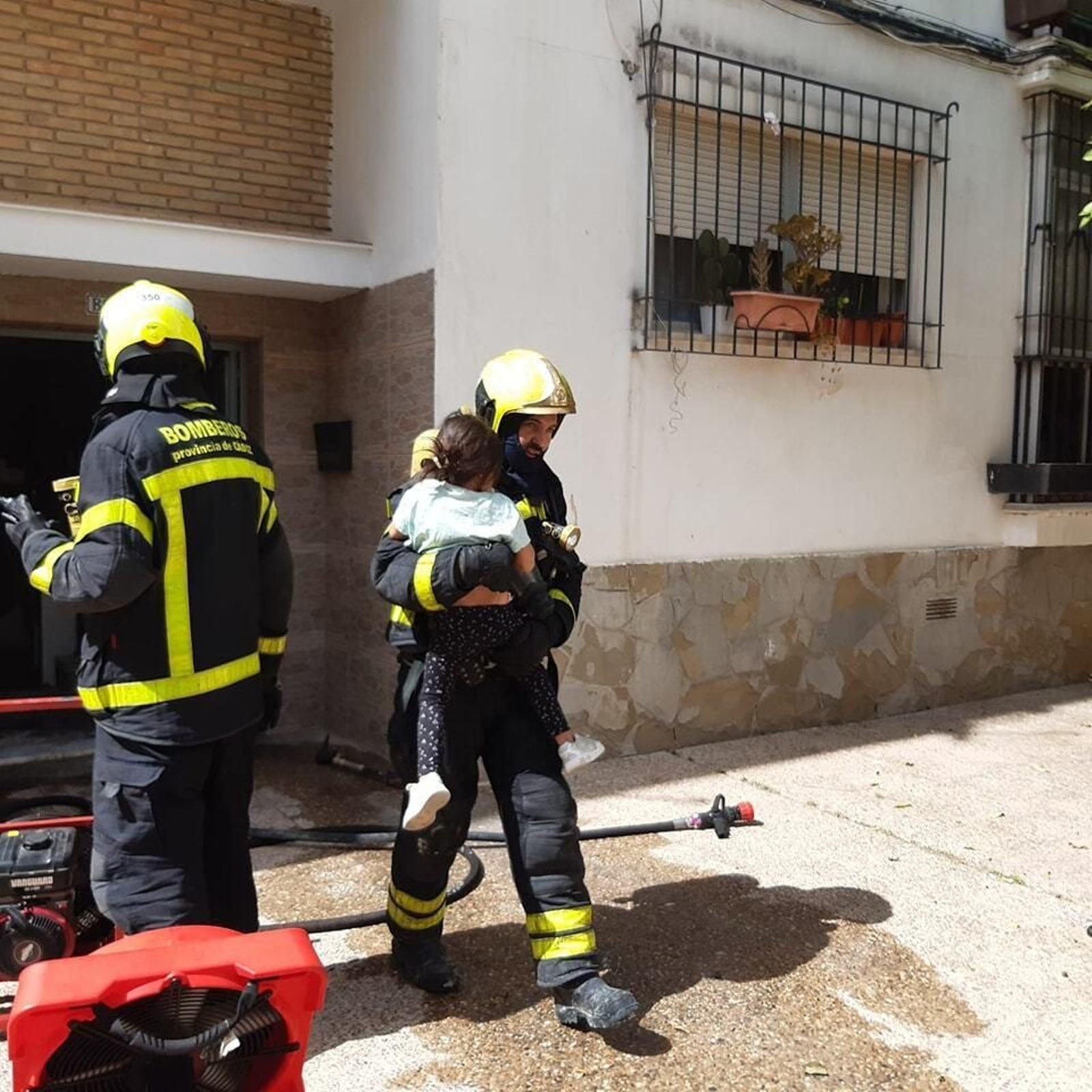 Un bombero desaloja a uno de los menores, tras el incendio localizado en un bloque de San Eloy, en Vallesequillo.