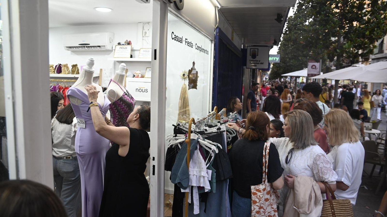 Varias mujeres observan la ropa de una tienda. Varias mujeres observan la ropa de una tienda.