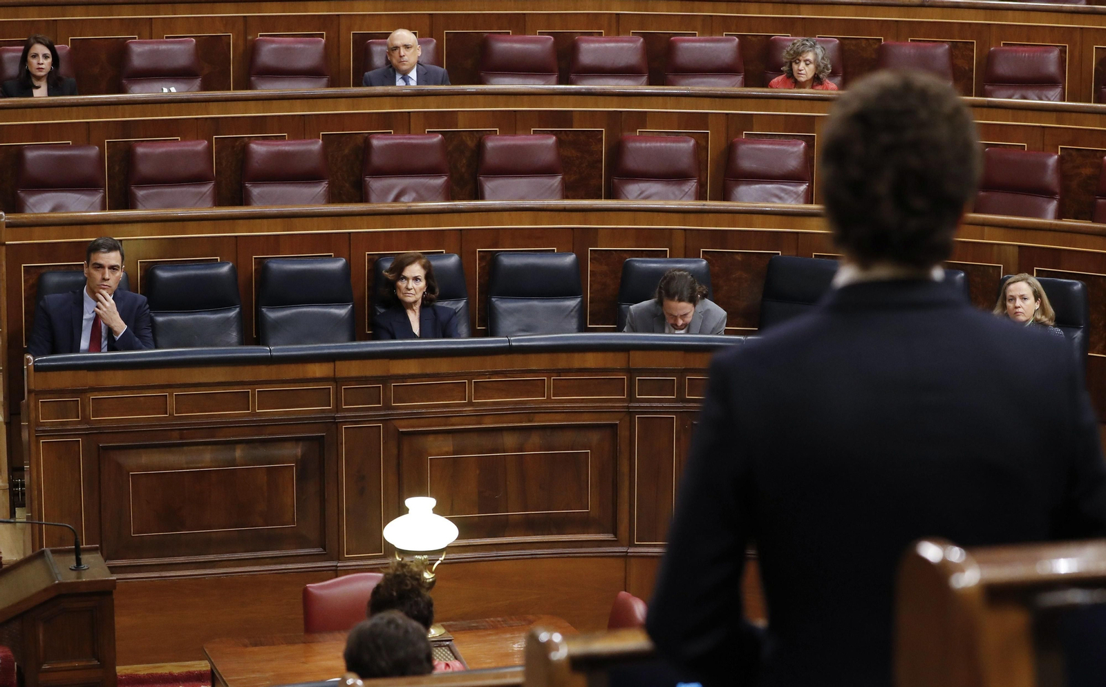 El presidente del Gobierno, Pedro Sánchez, escucha al líder de la oposición, Pablo Casado (de espaldas) durante el pleno de este miércoles en el Congreso.