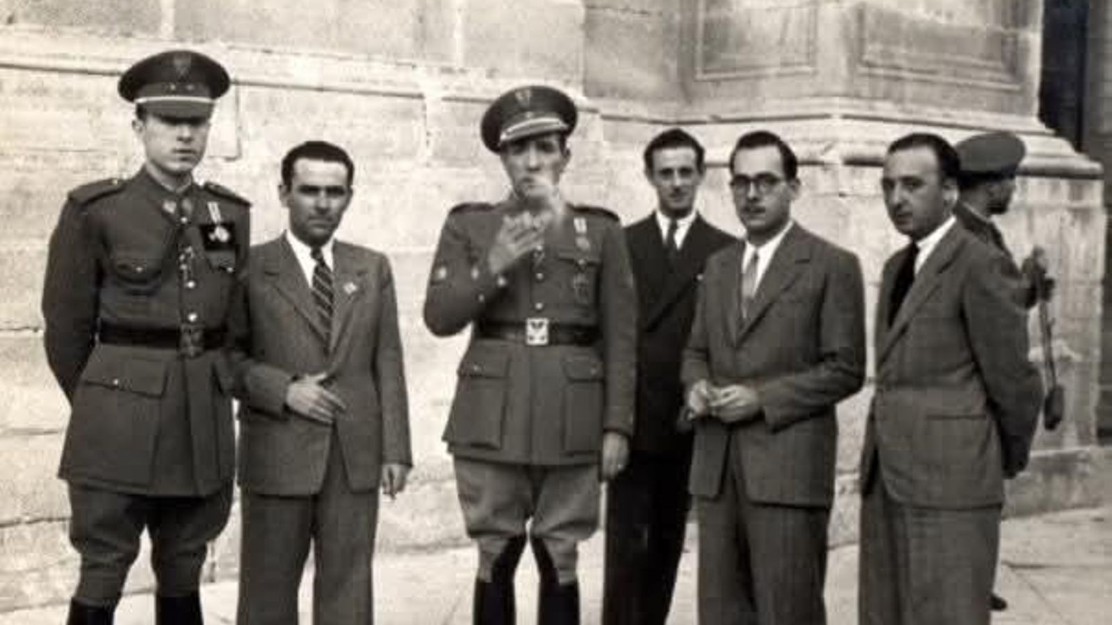 El teniente José Escobedo (izq.) luce sus condecoraciones obtenidas en Rusia, junto al comandante Román (centro), fumando. Catedral de Jaén, 1942.