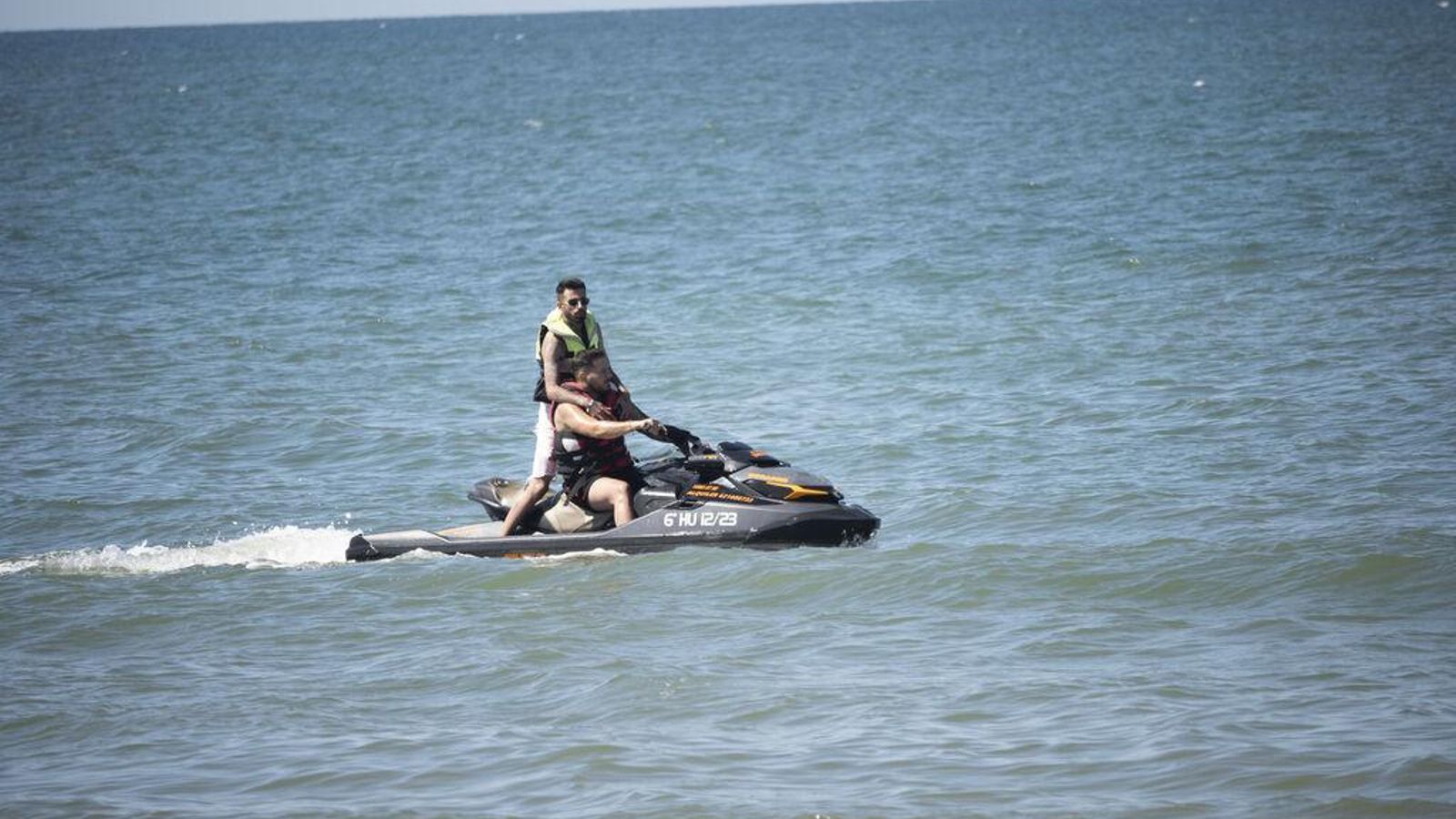 Dos hombres en una moto de agua en la playa.