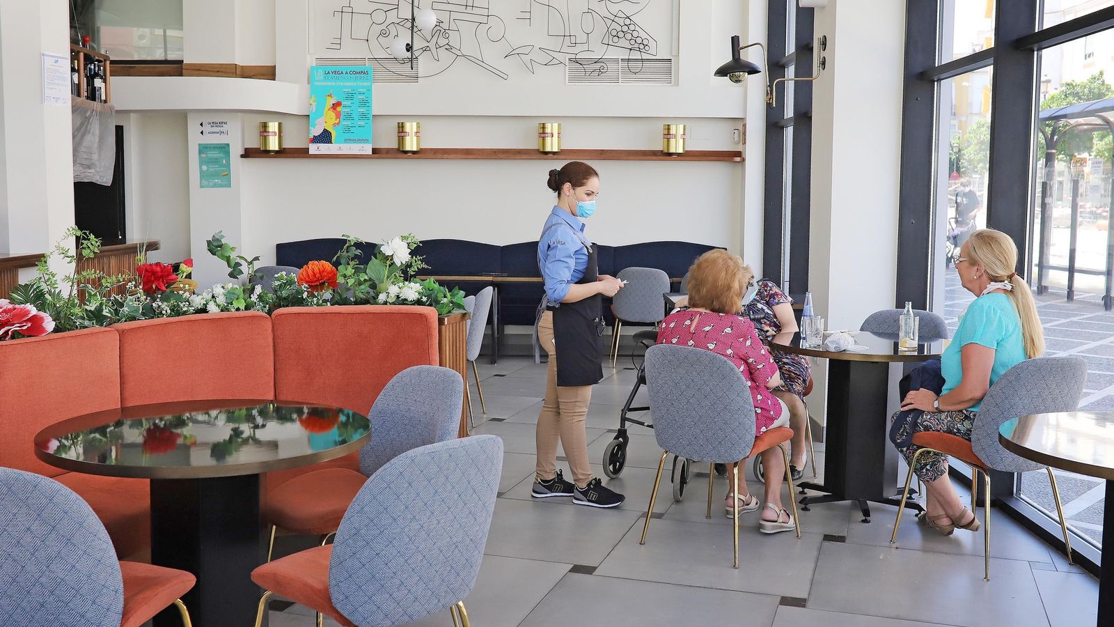 Una camarera se dispone a servir una mesa en el interior de La Vega.