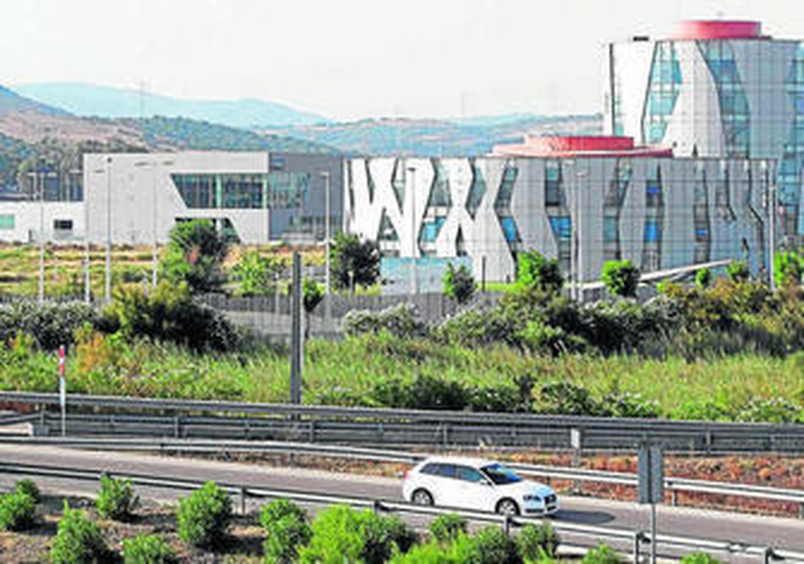 Al fondo, un concesionario de coches y el edificio de servicios de la ZAL.