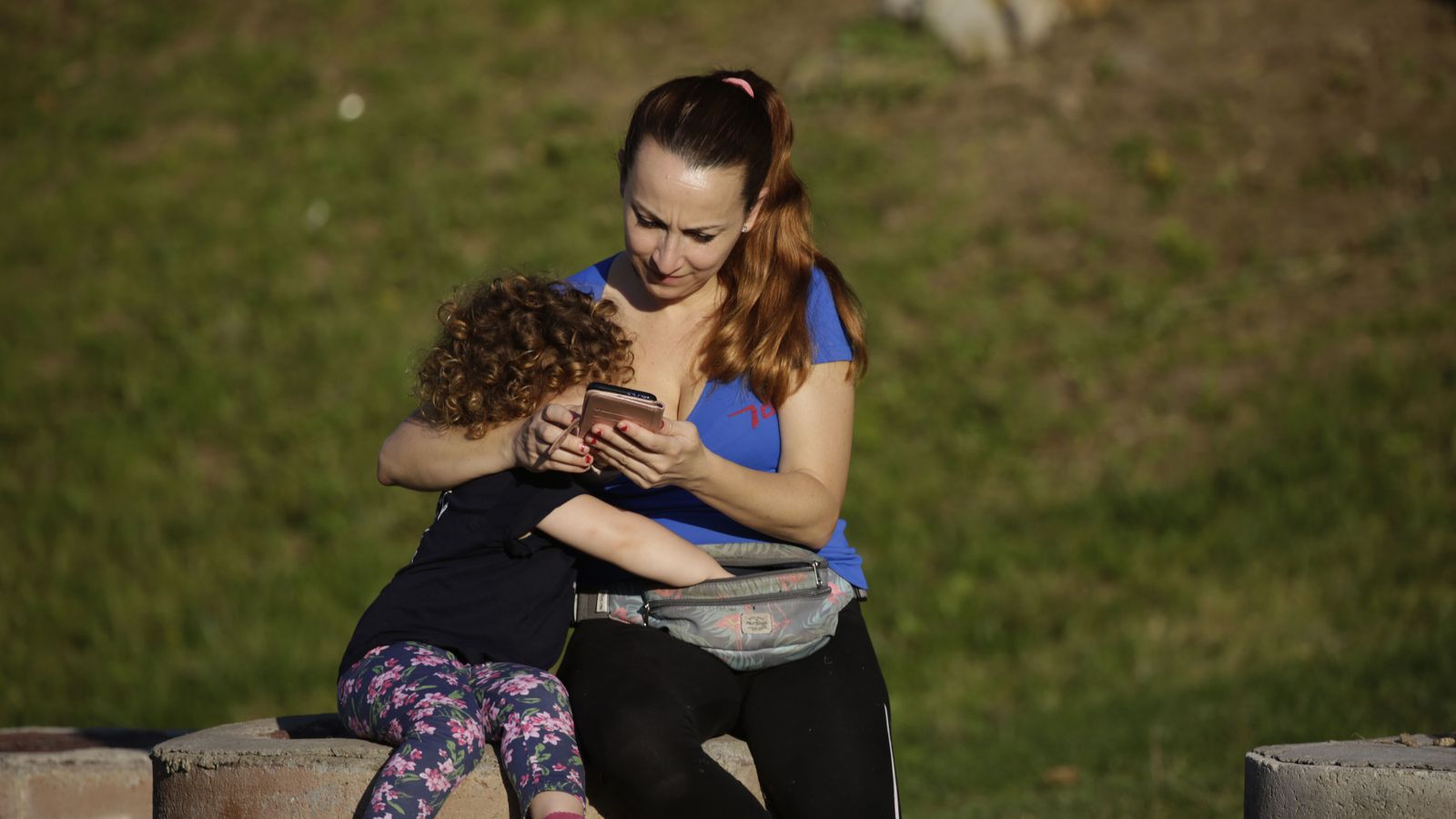 Una mujer junto a su hija descansa al aire libre