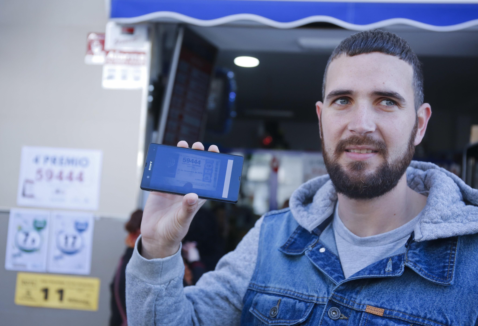 Jesús Carballo posa con una fotografía del décimo del cuarto premio en el teléfono móvil.