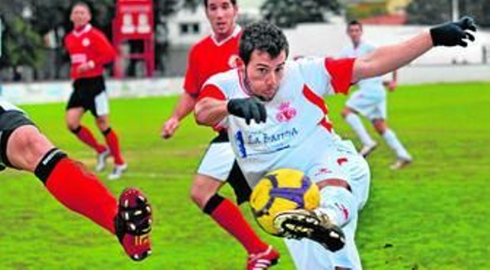 Adrián Gallardo golpea con violencia el esférico ante la oposición de un futbolista sanroqueño.