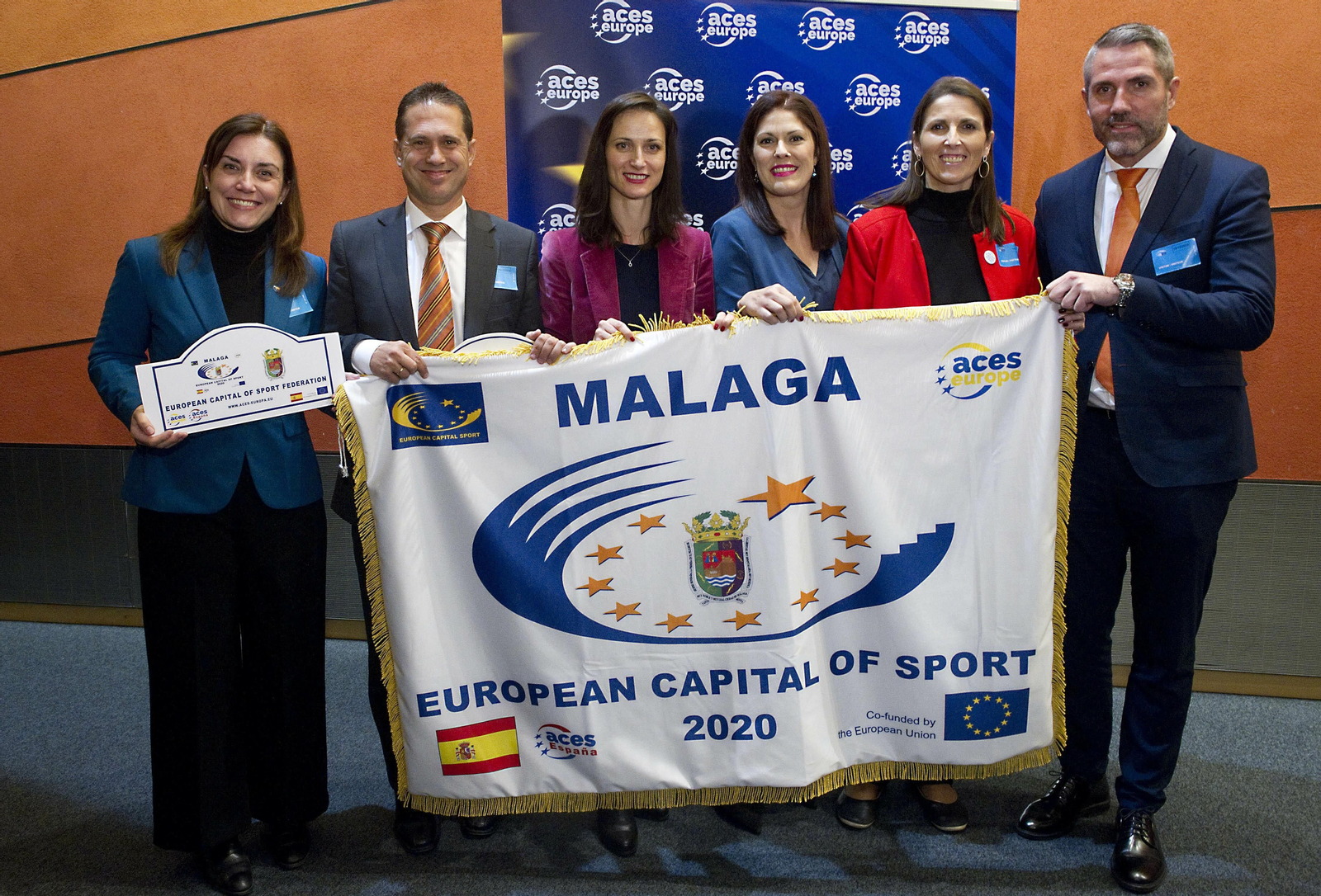 La representación malagueña recibe la bandera de Málaga 2020.