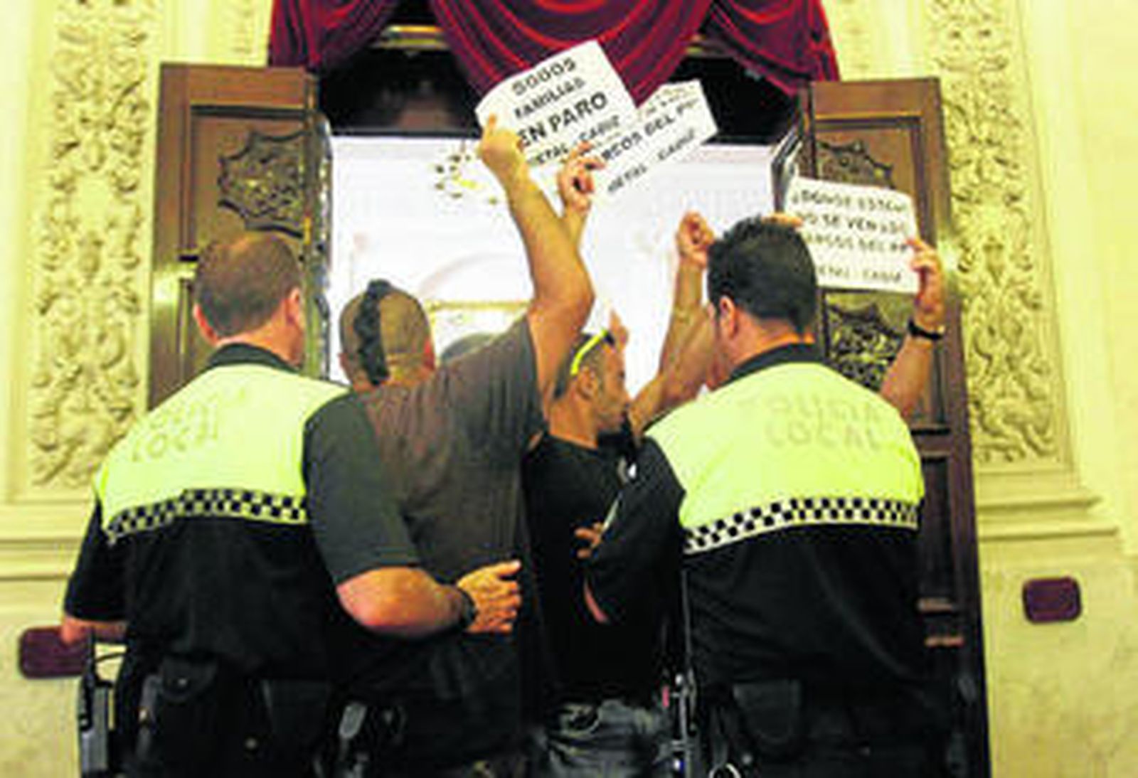 Algunos ciudadanos expresan sus protestas en la puerta del Salón de Plenos.
