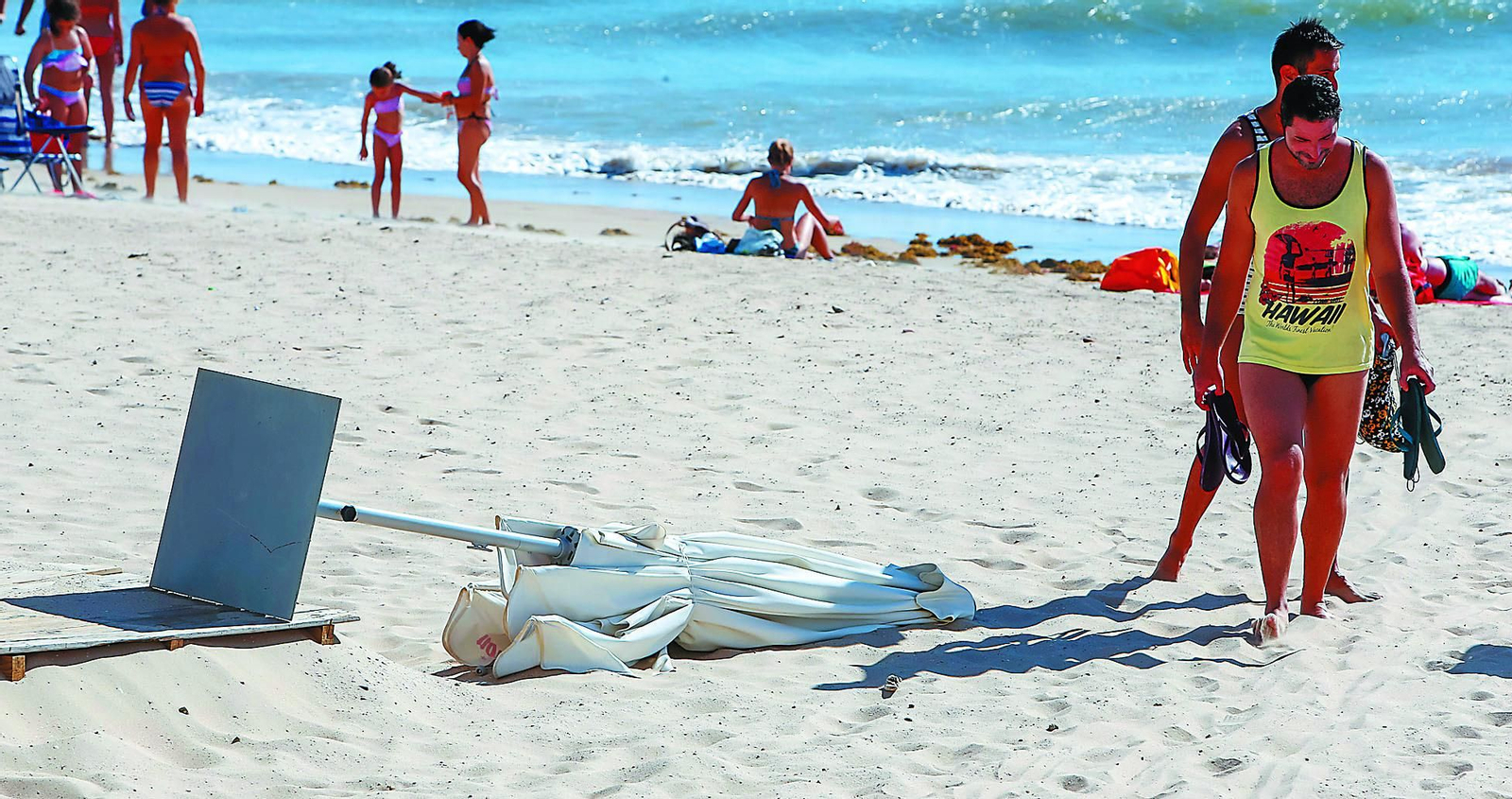 Imagen de archivo de una sombrilla derribada por el levante en la playa de Cádiz