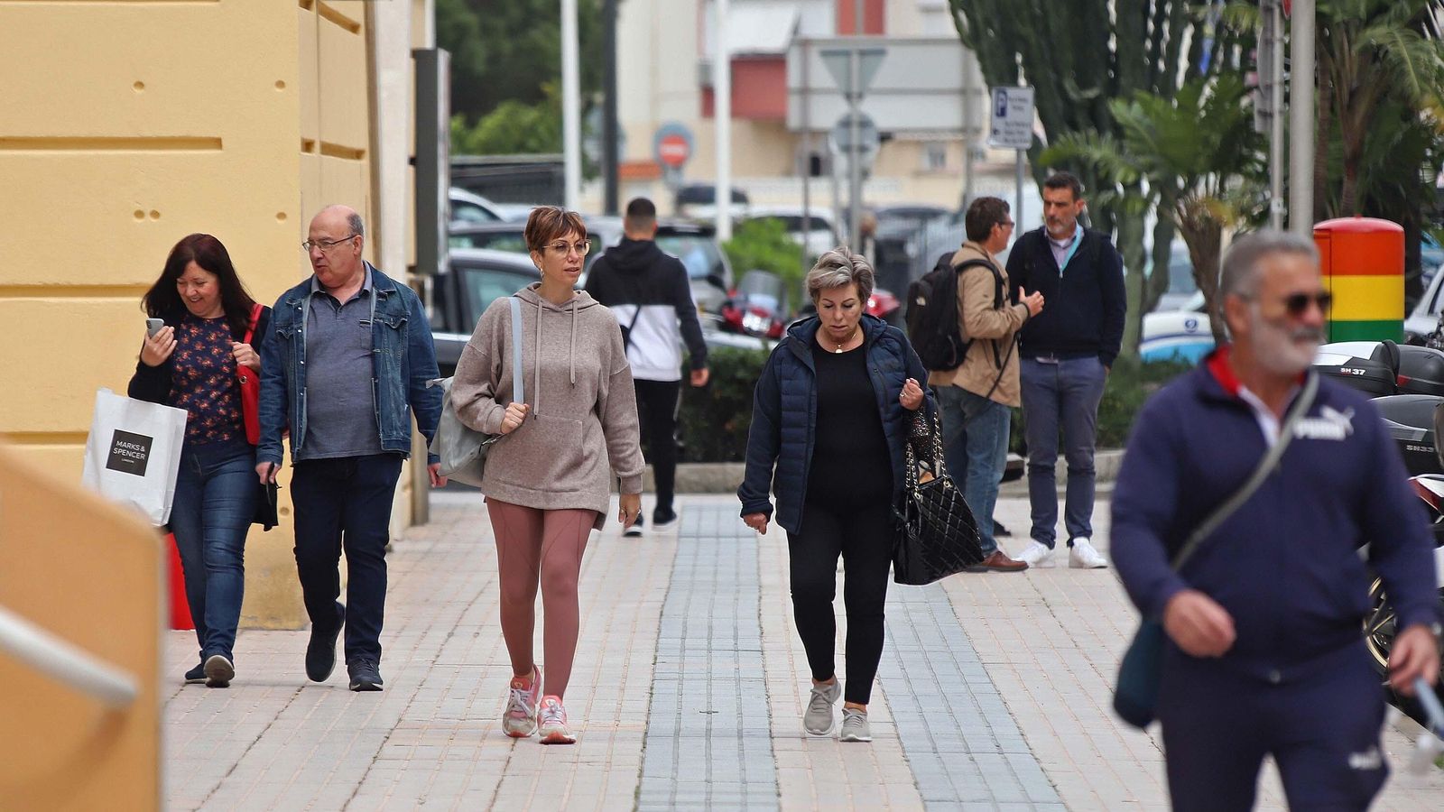 Varias personas sin mascarillas en una calle de Gibraltar en la que no es obligatorio.