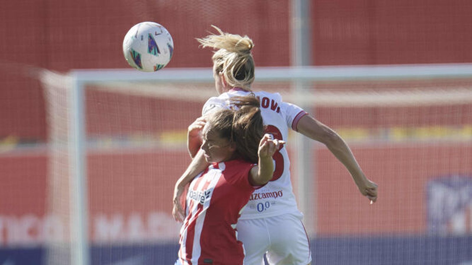 Cahynová salta con una jugadora del Atlético de Madrid.