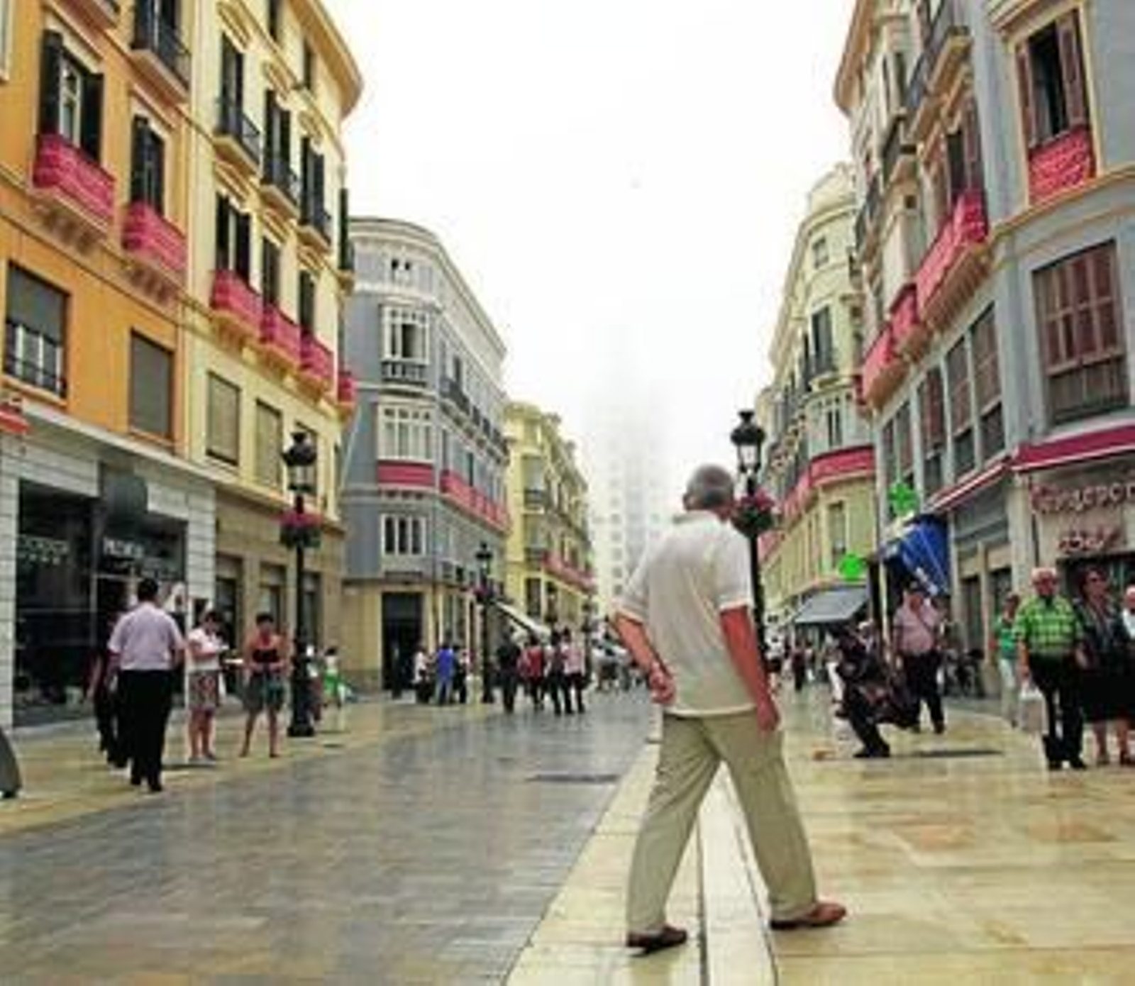 Una espesa niebla velaba ayer por la mañana la visión de la Equitativa desde la calle Larios.