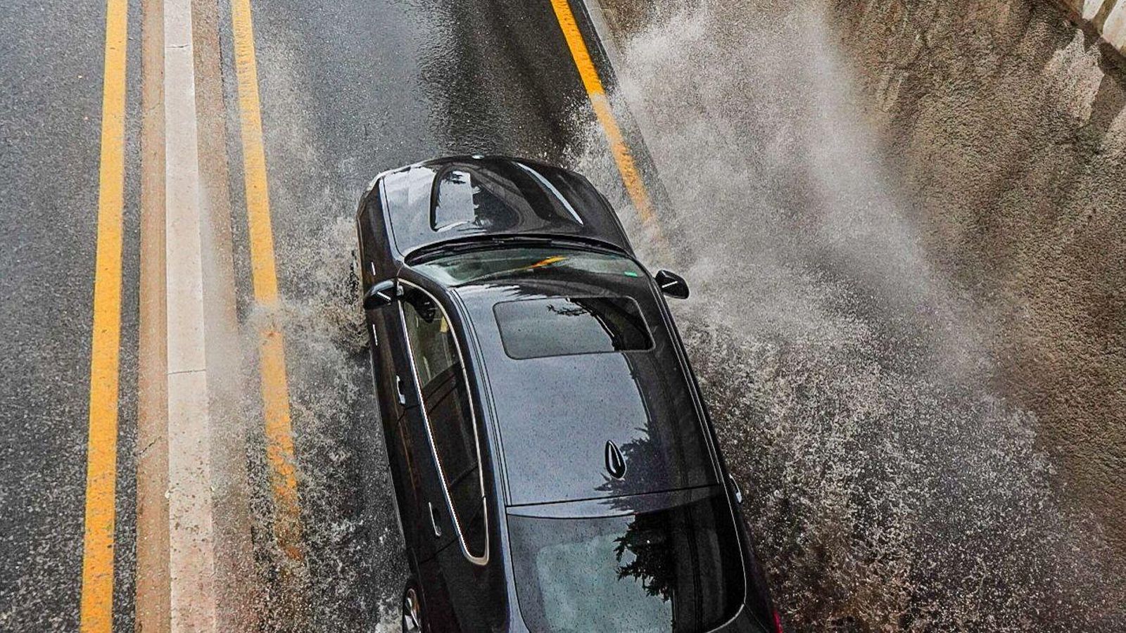 Un coche pasa por encima de un charco de agua.