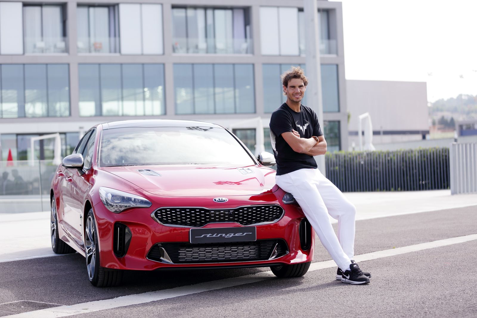 El tenista mallorquín junto a su nuevo Kia Stinger