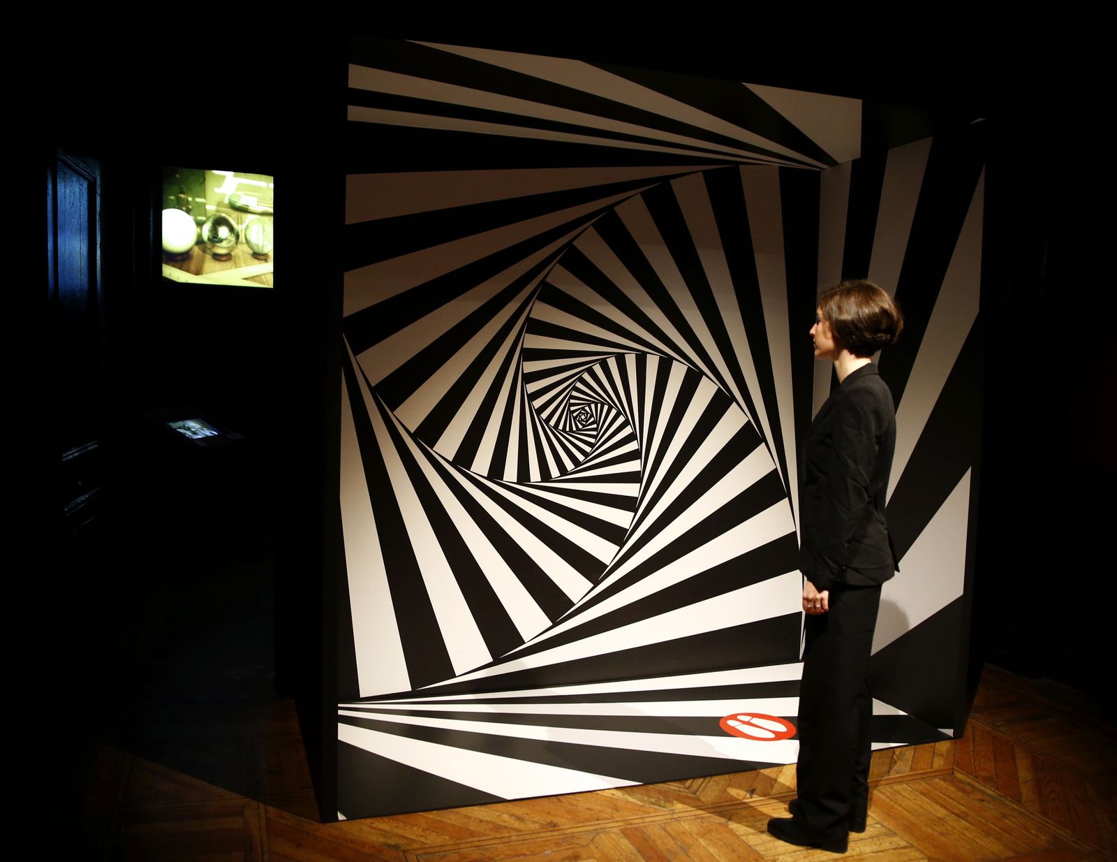 Una mujer contempla en el madrileño Palacio de Gaviria una de las hipnóticas obras del artista holandés.