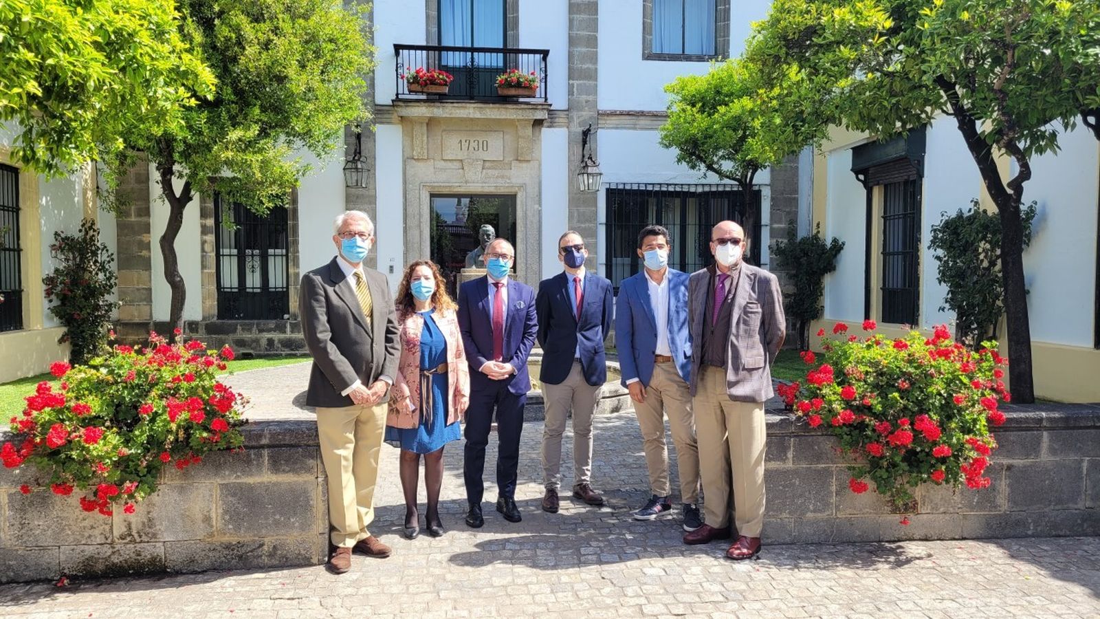 Los responsables de Bodegas Fundador y Cáritas, tras la entrega de la ayuda.