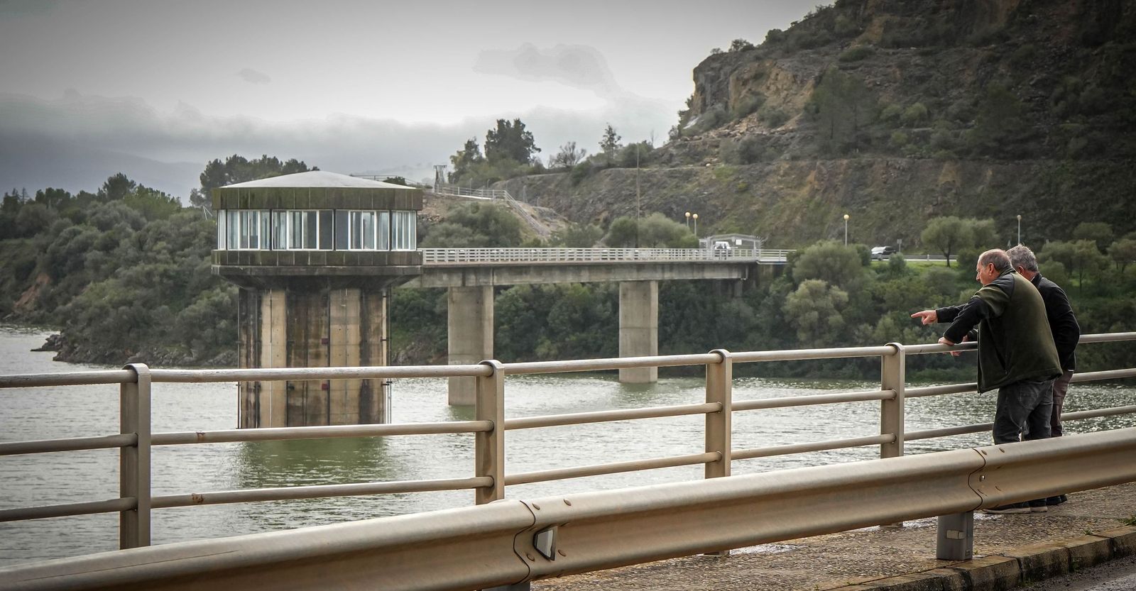 Dos hombres contemplan ayer desde la zona superior de la presa el llenado del embalse de Guadalcacín.