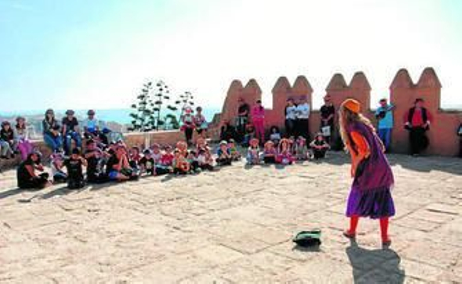 Un grupo de jóvenes atienden las explicaciones sobre la historia de la Alcazaba.