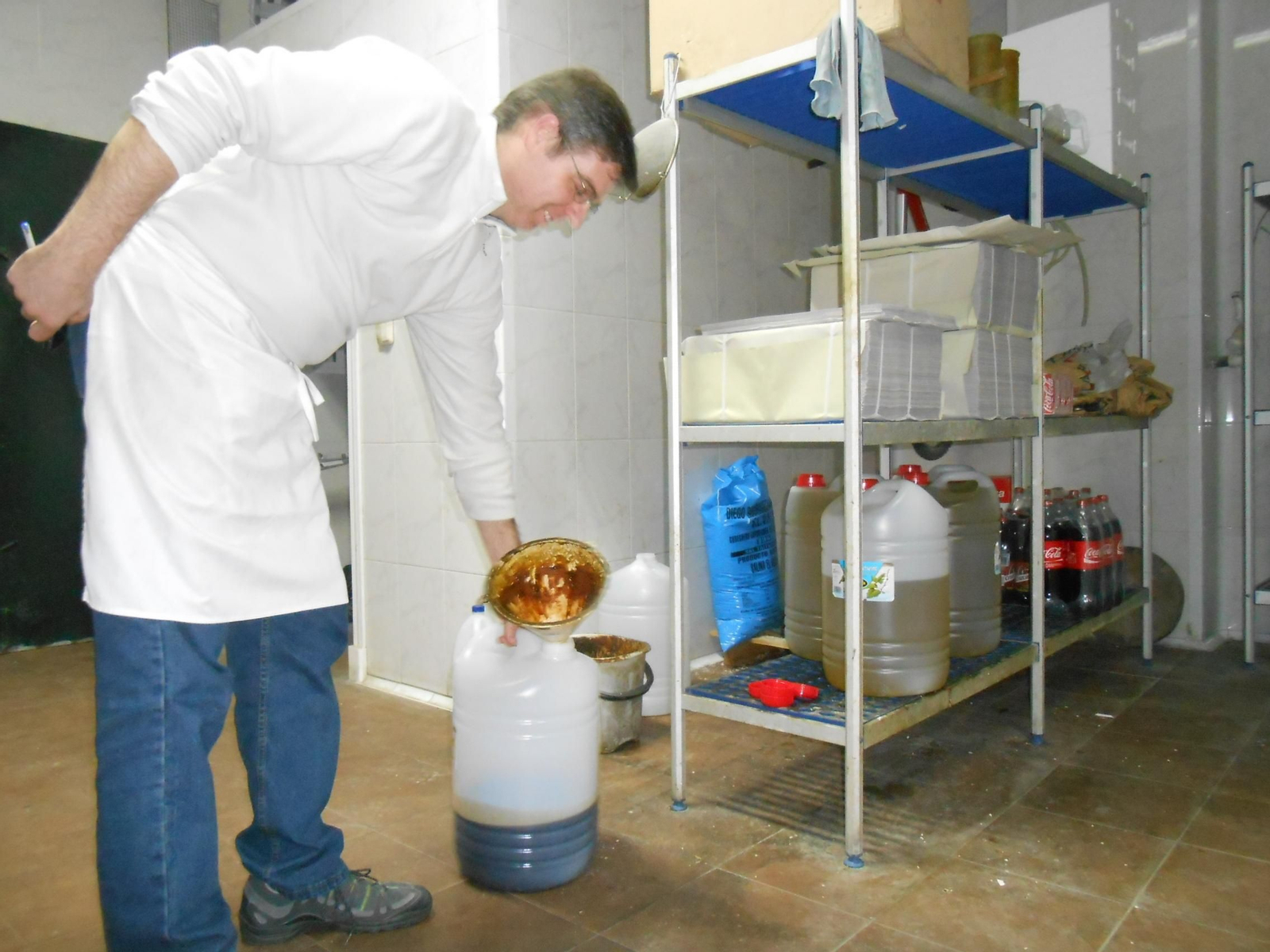 Un trabajador de hostelería manipulando una garrafa de aceite usado.