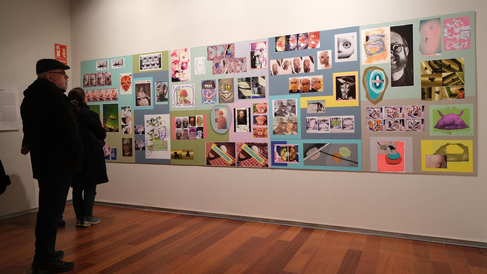 Varios visitantes contemplan las obras expuestas.