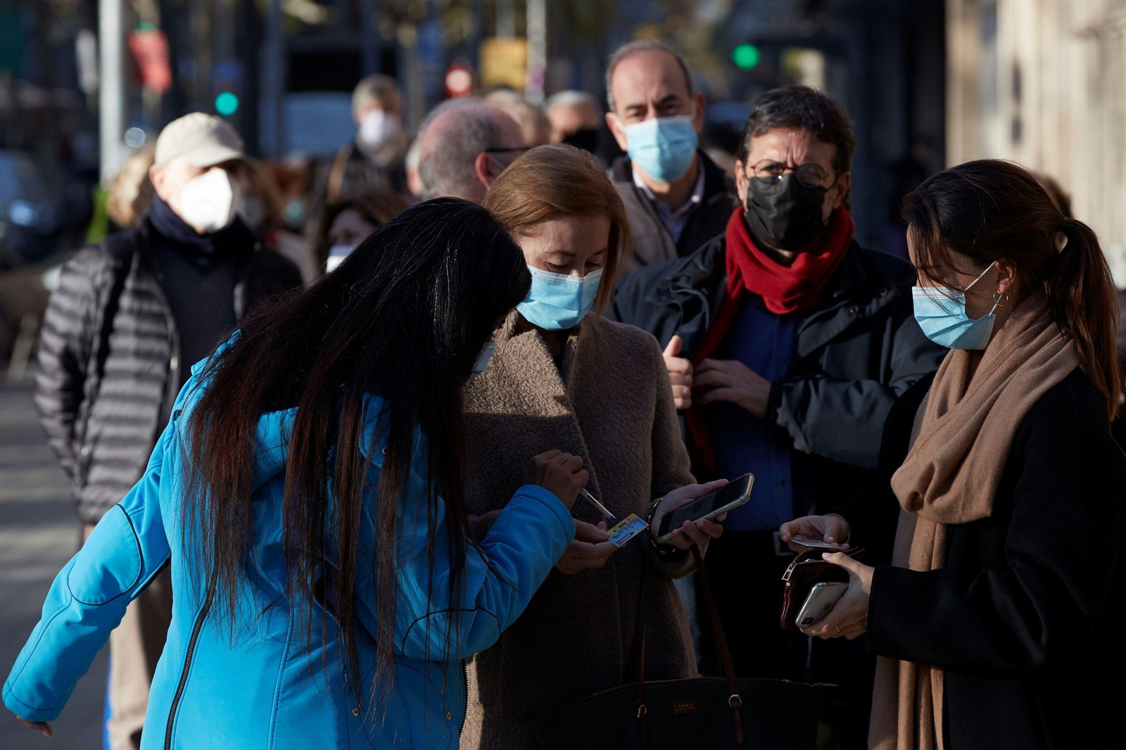 Varias personas hacen cola para vacunarse en un punto de vacunación de Barcelona.