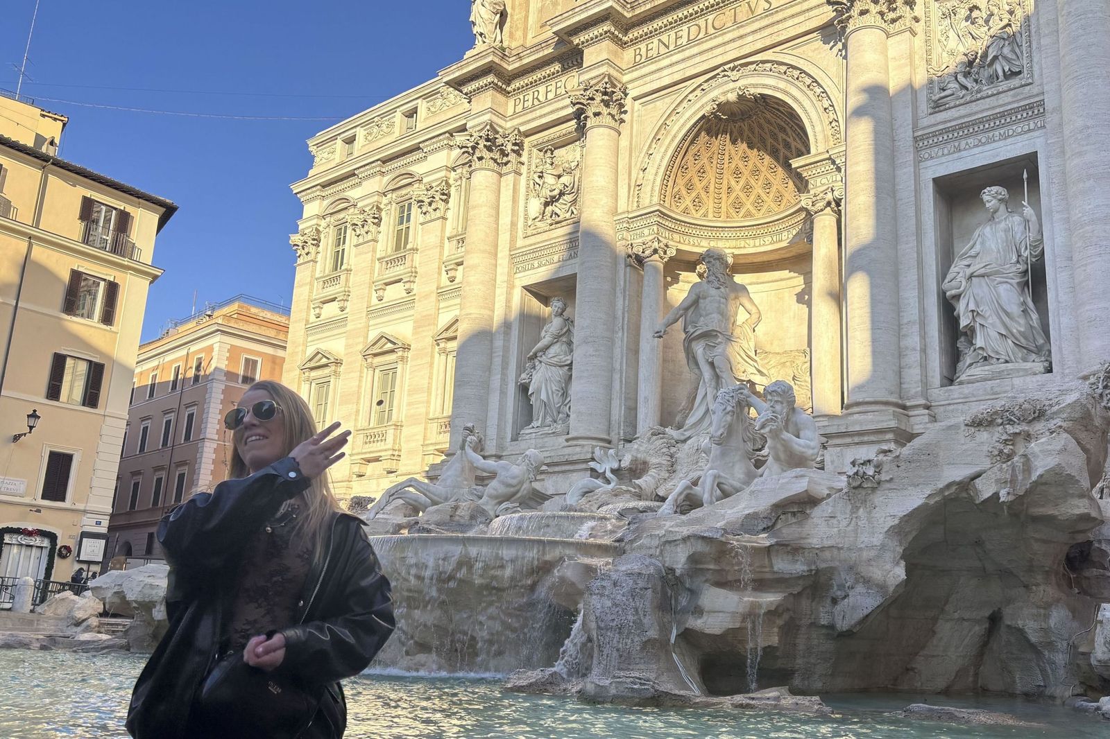 Una joven echa una moneda en la Fontana di Trevi.