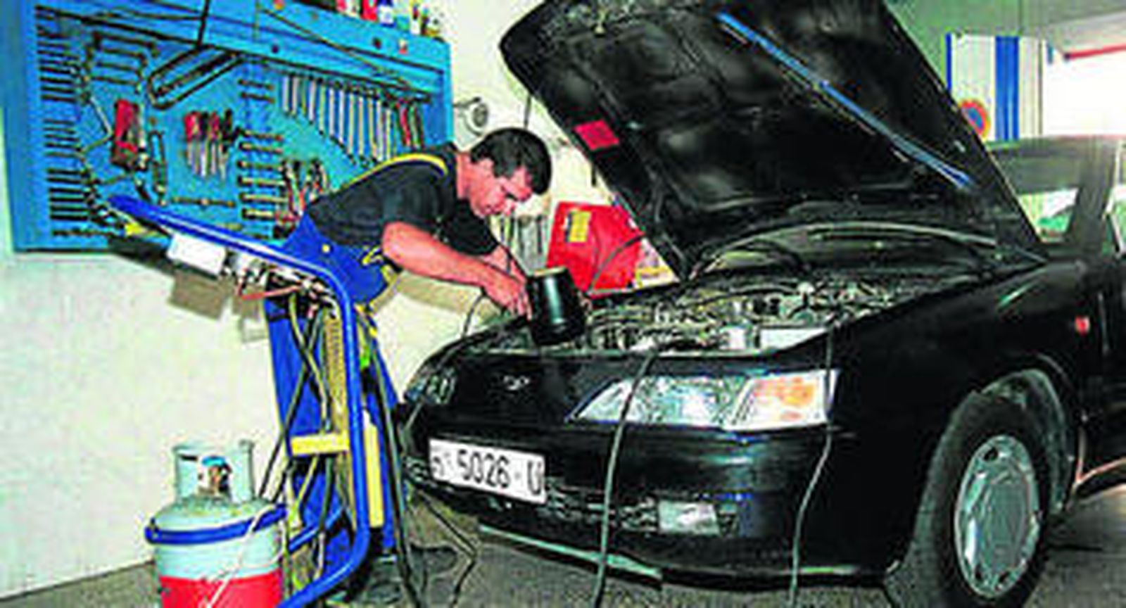 Un mecánico repara el motor de un vehículo.