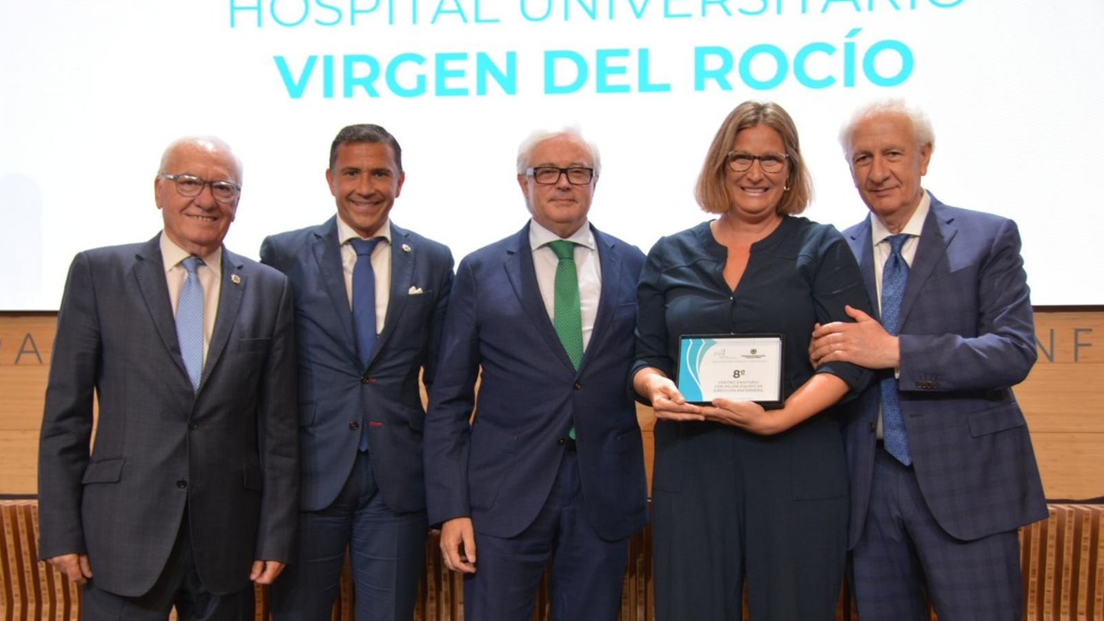 Representantes del equipo directivo de Enfermería del Virgen del Rocío recogen el galardón.