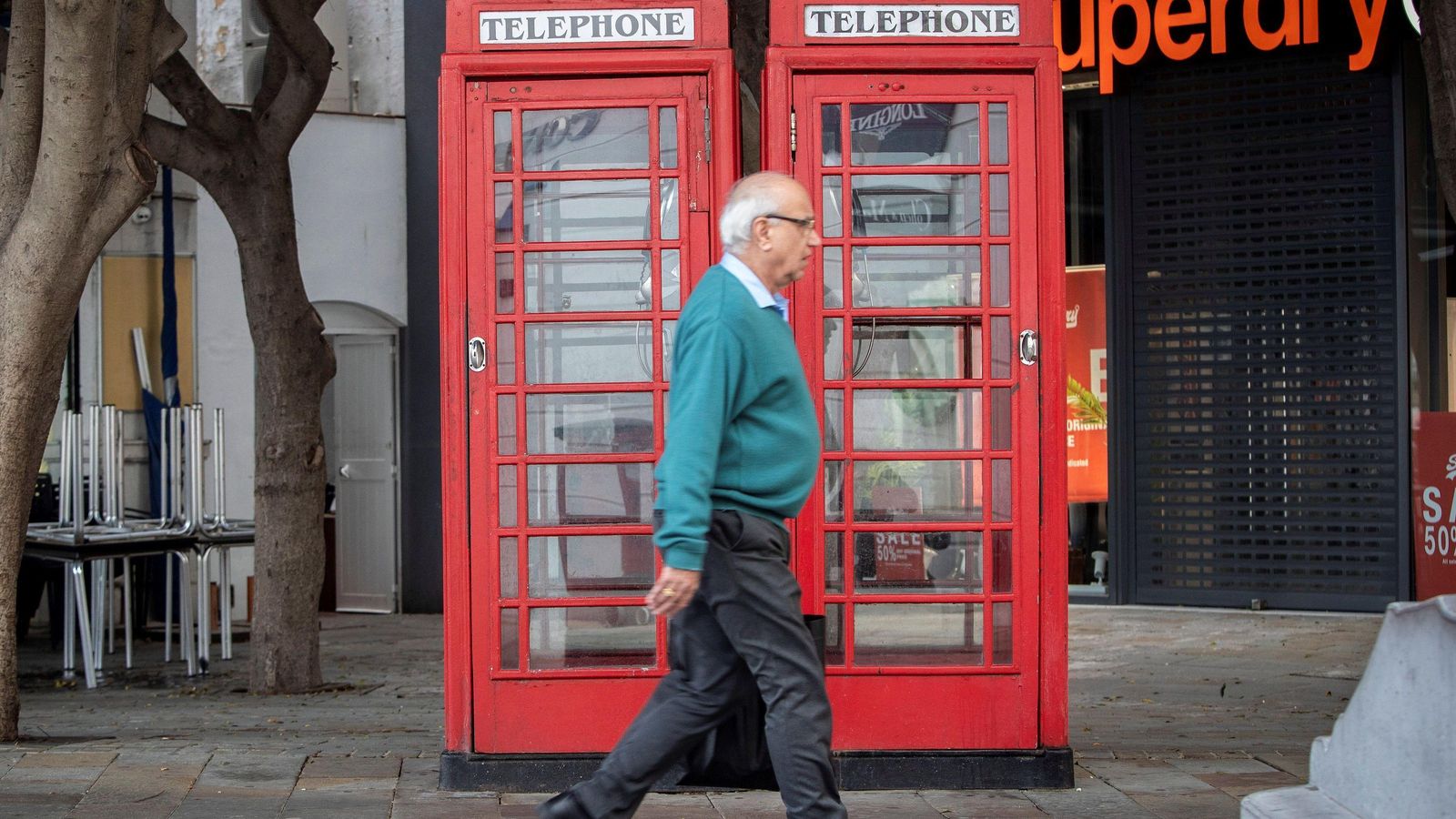 Un hombre camina por delante de las célebres cabinas telefónicas de Gibraltar.