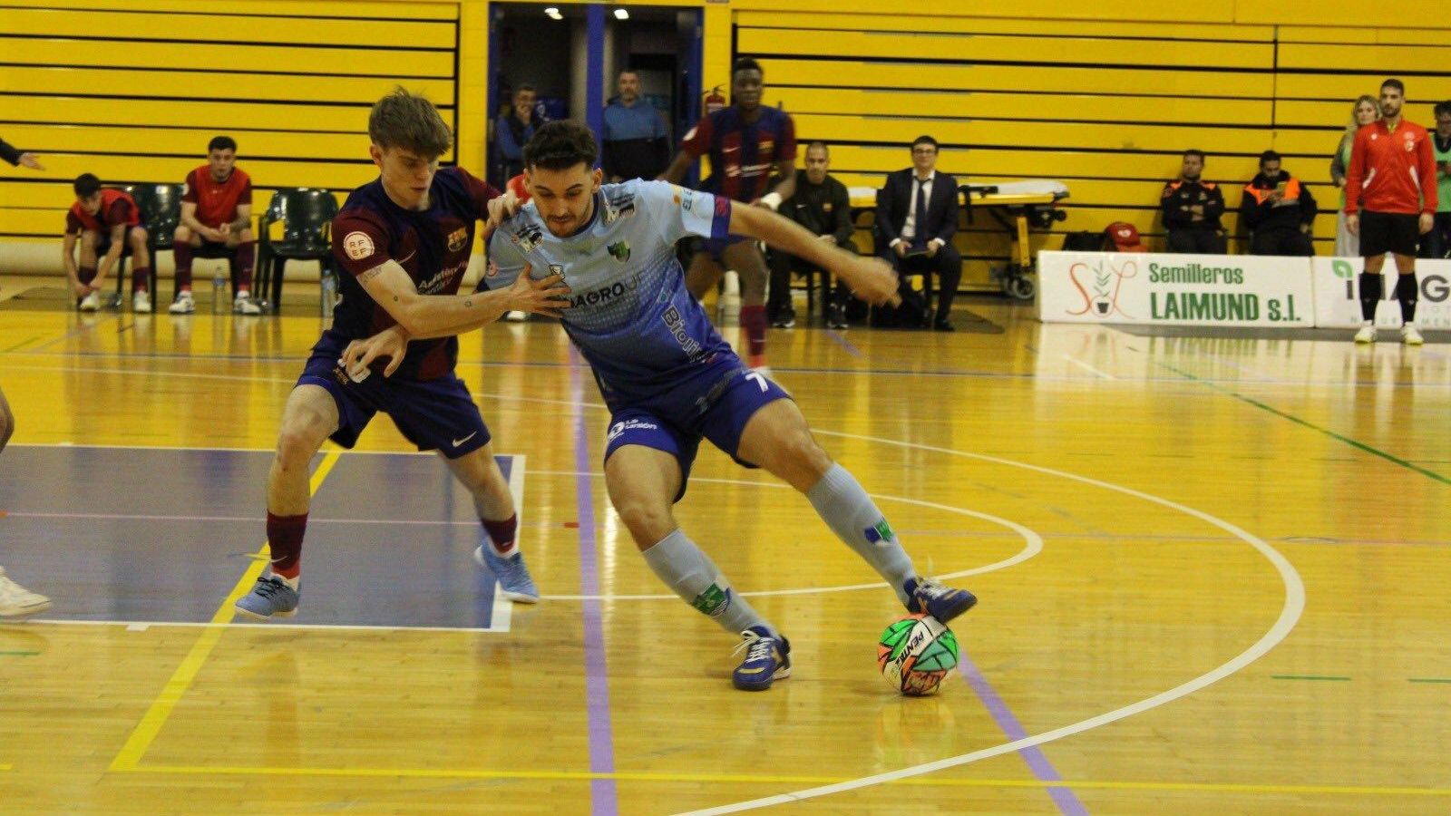 Juanan protege de espaldas el esférico ante la defensa del jugador blaugrana.