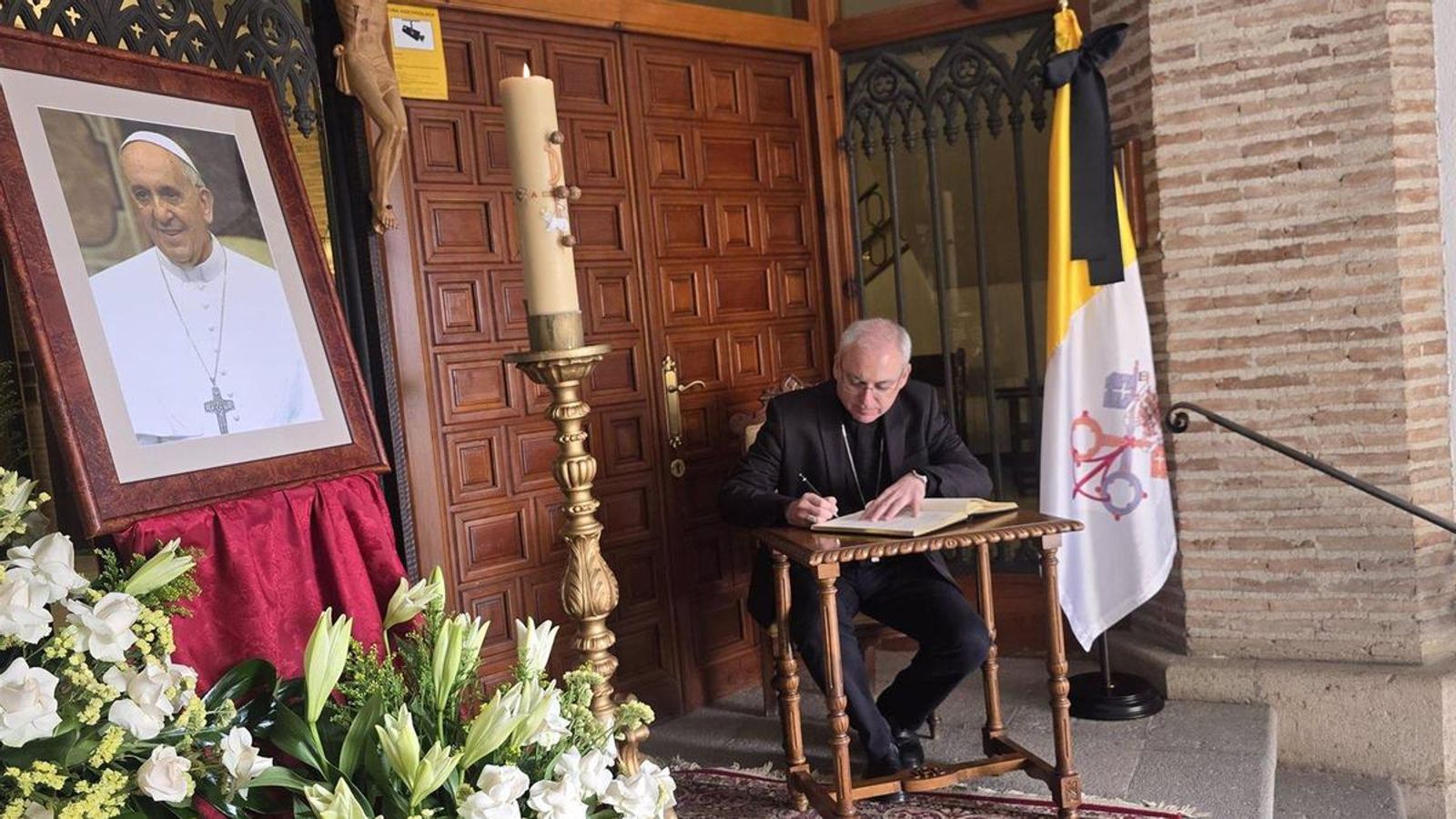 El obispo firmando en el libro de condolencias.