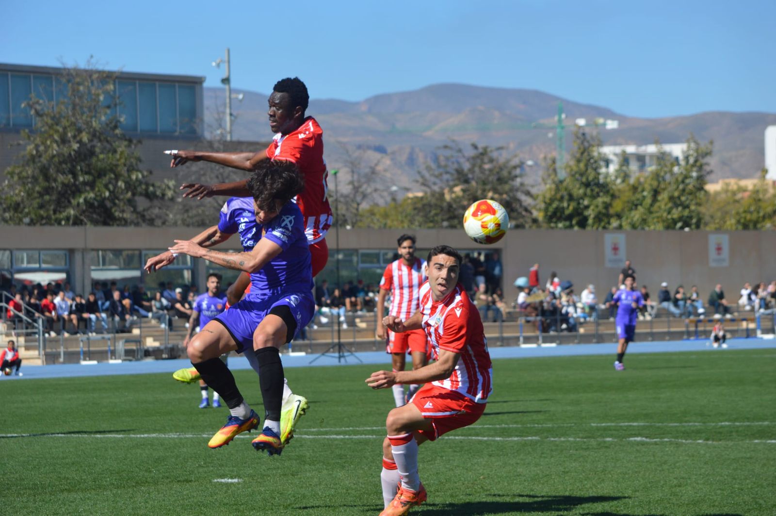 Tommy Montenegro lucha un balón aéreo con dos jugadores del Almería B.