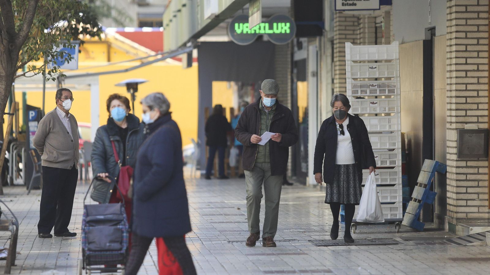 Varias personas caminando con mascarilla en el barrio de El Palo, en Málaga