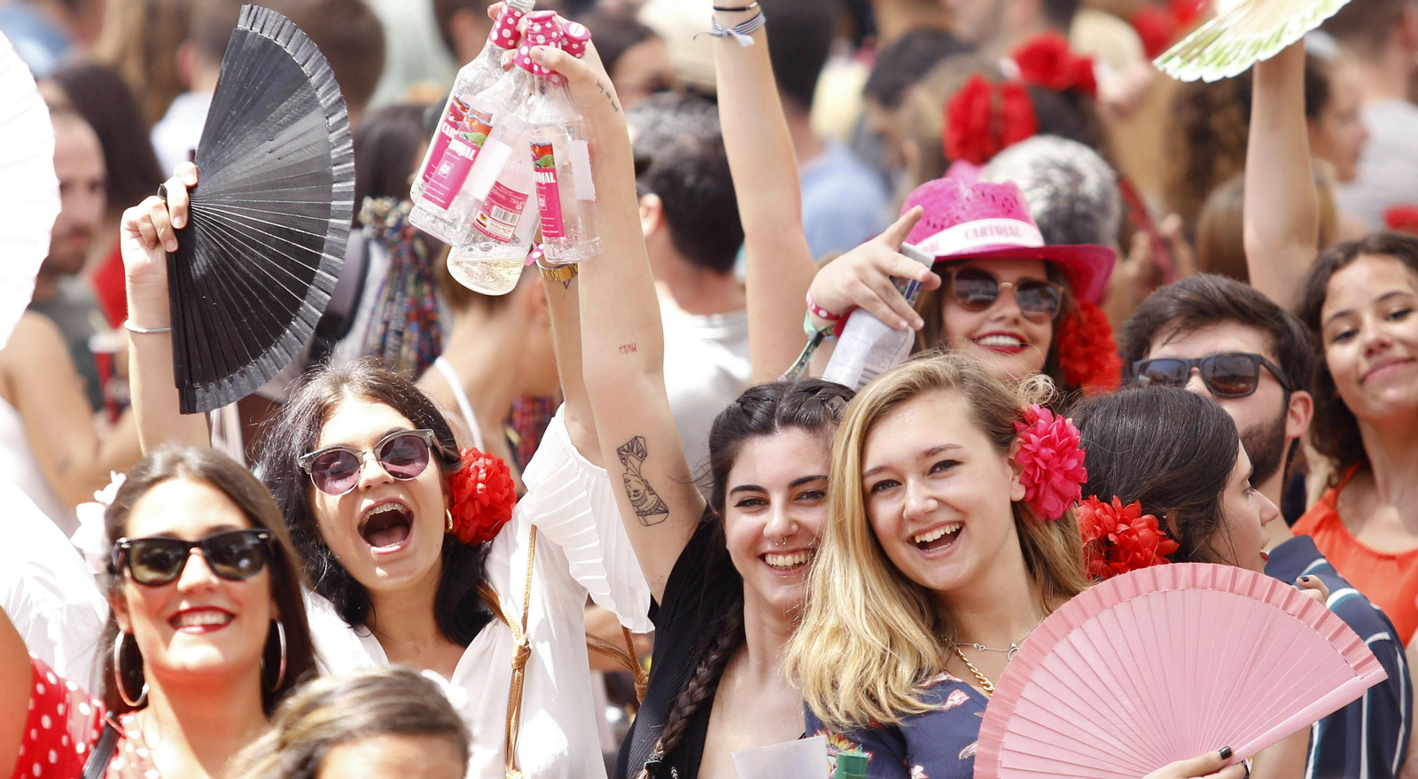 Un grupo de jóvenes con botellas de vino dulce en la Feria de Málaga.