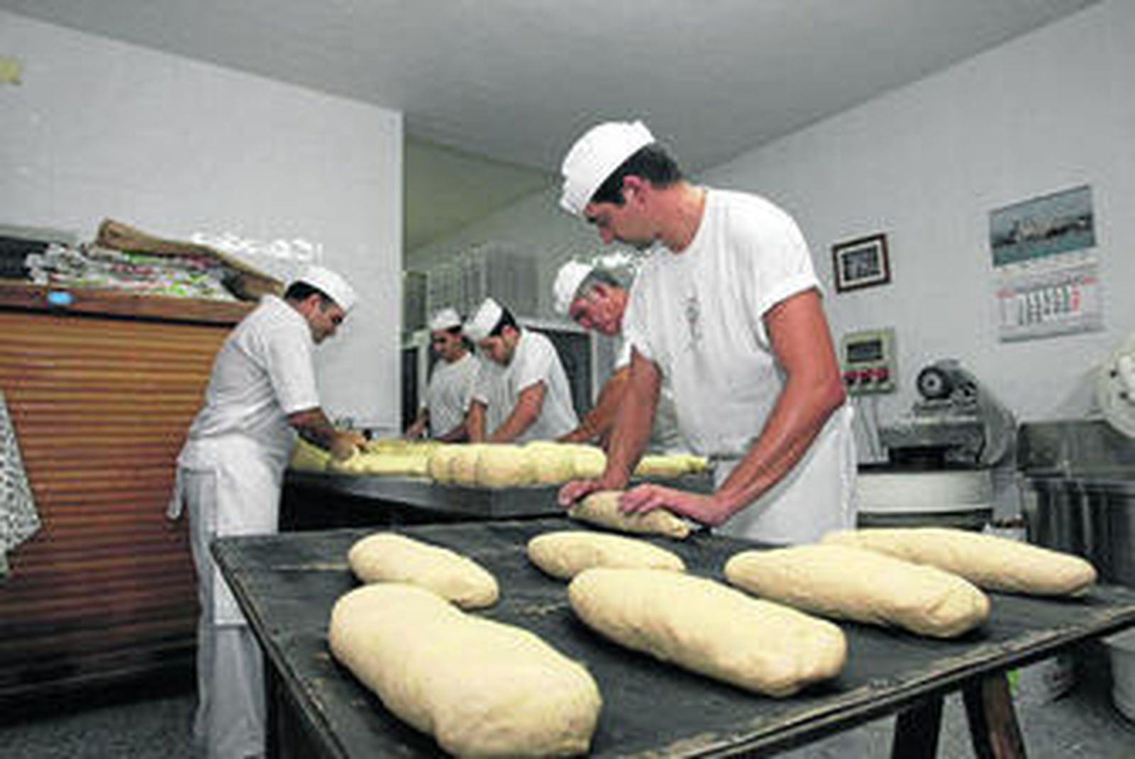 Los maestros de mesa amasan el pan de Pelayo, la madrugada de ayer sábado.